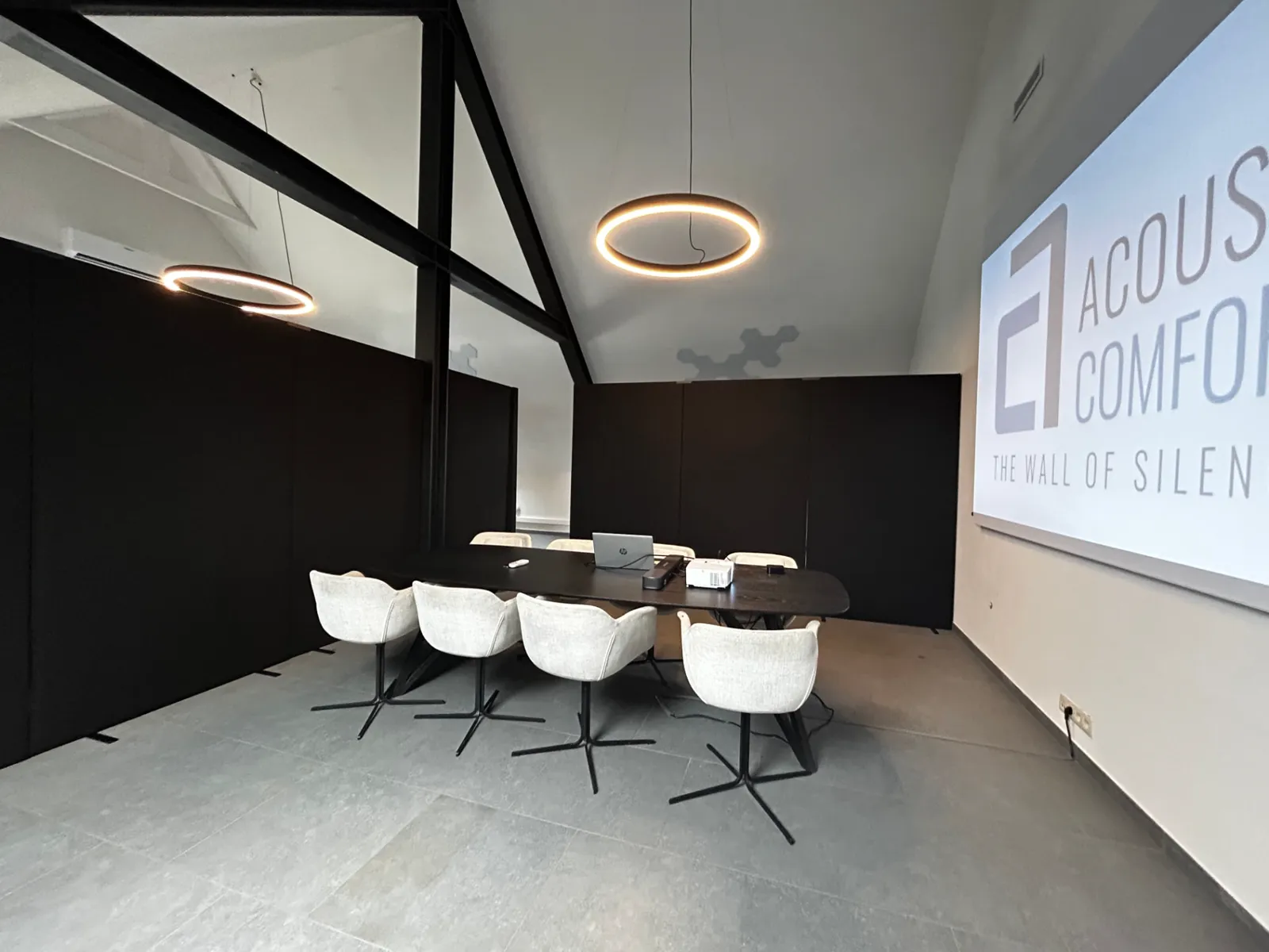 Salle de réunion avec écran de projection acoustique et cloisons acoustiques noires
