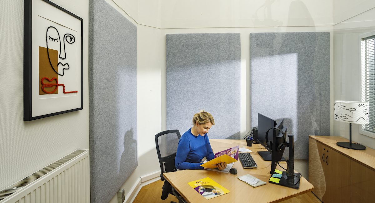 Akoestische wandpanelen achter een werkplek in een kantoorruimte