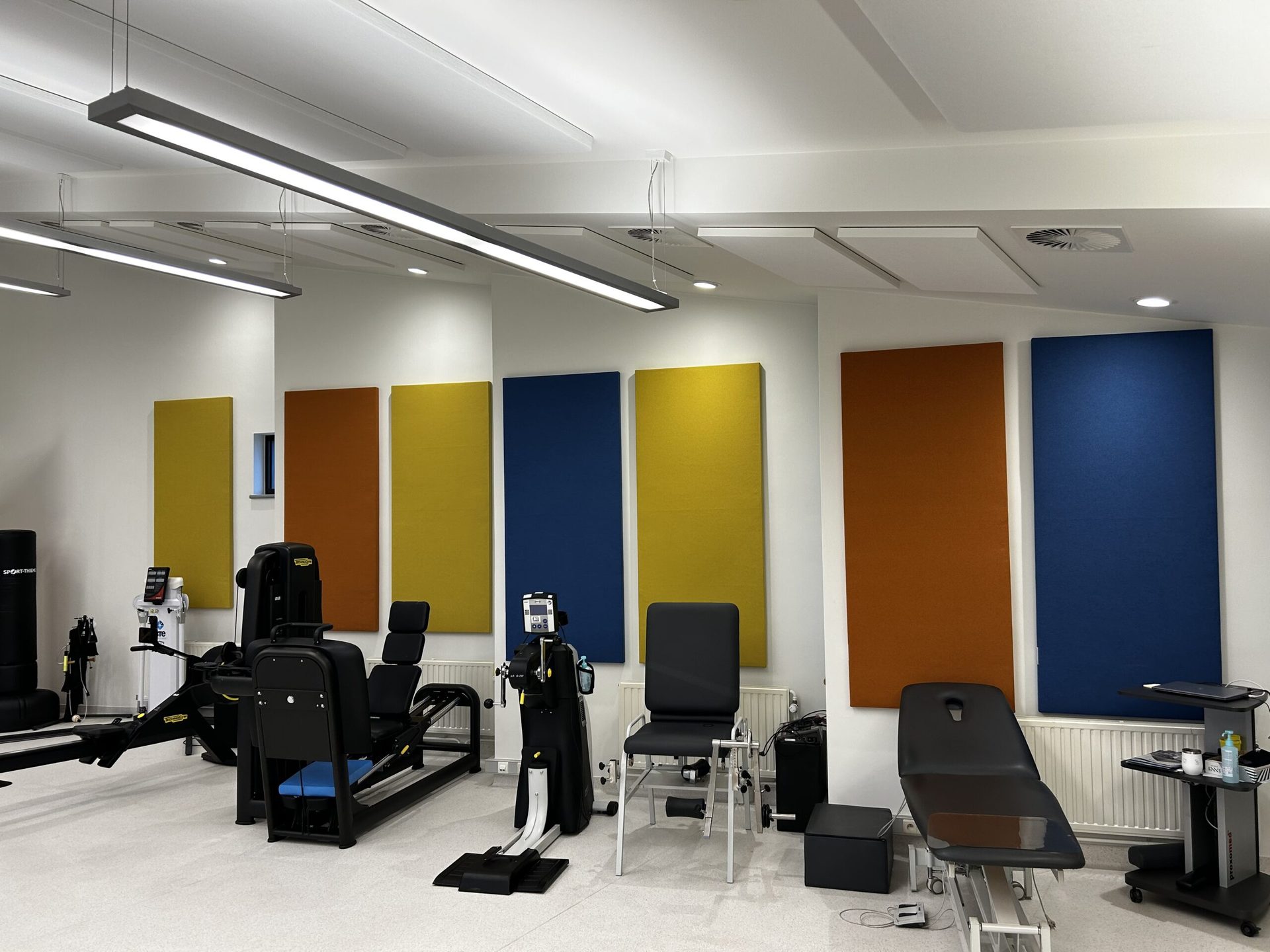 Kleurrijke akoestische wandpanelen in geel, blauw en oranje gemonteerd in een ruimte
