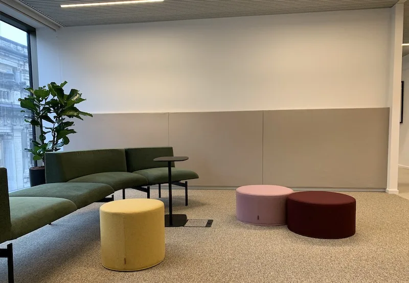 Akoestische wandpanelen in een kantoorlounge met zithoek
