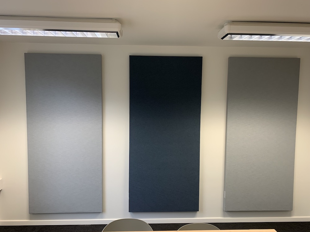 Akoestische wandpanelen in grijs en blauw aan een wand