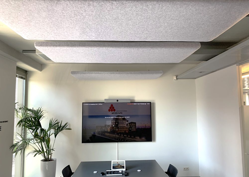 Witte akoestische plafondpanelen in een vergaderruimte met scherm