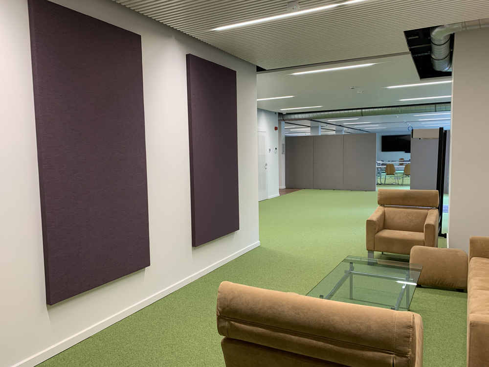 Paarse akoestische wandpanelen in een kantoorlounge