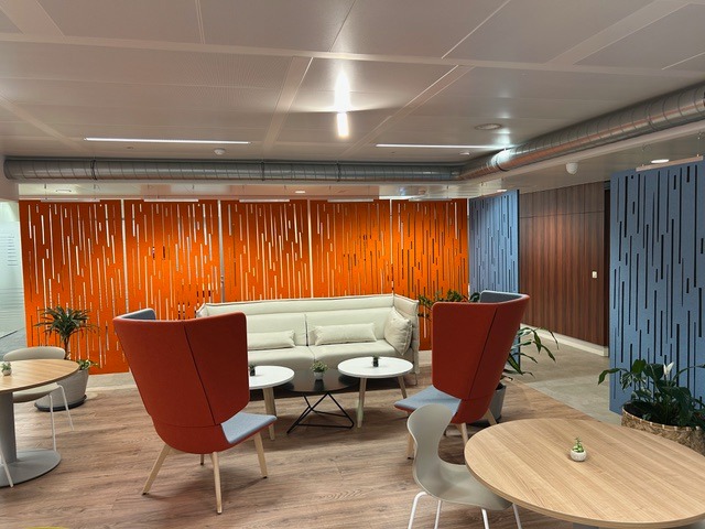 Decoratieve akoestische wandpanelen in oranje en blauw in een loungeruimte