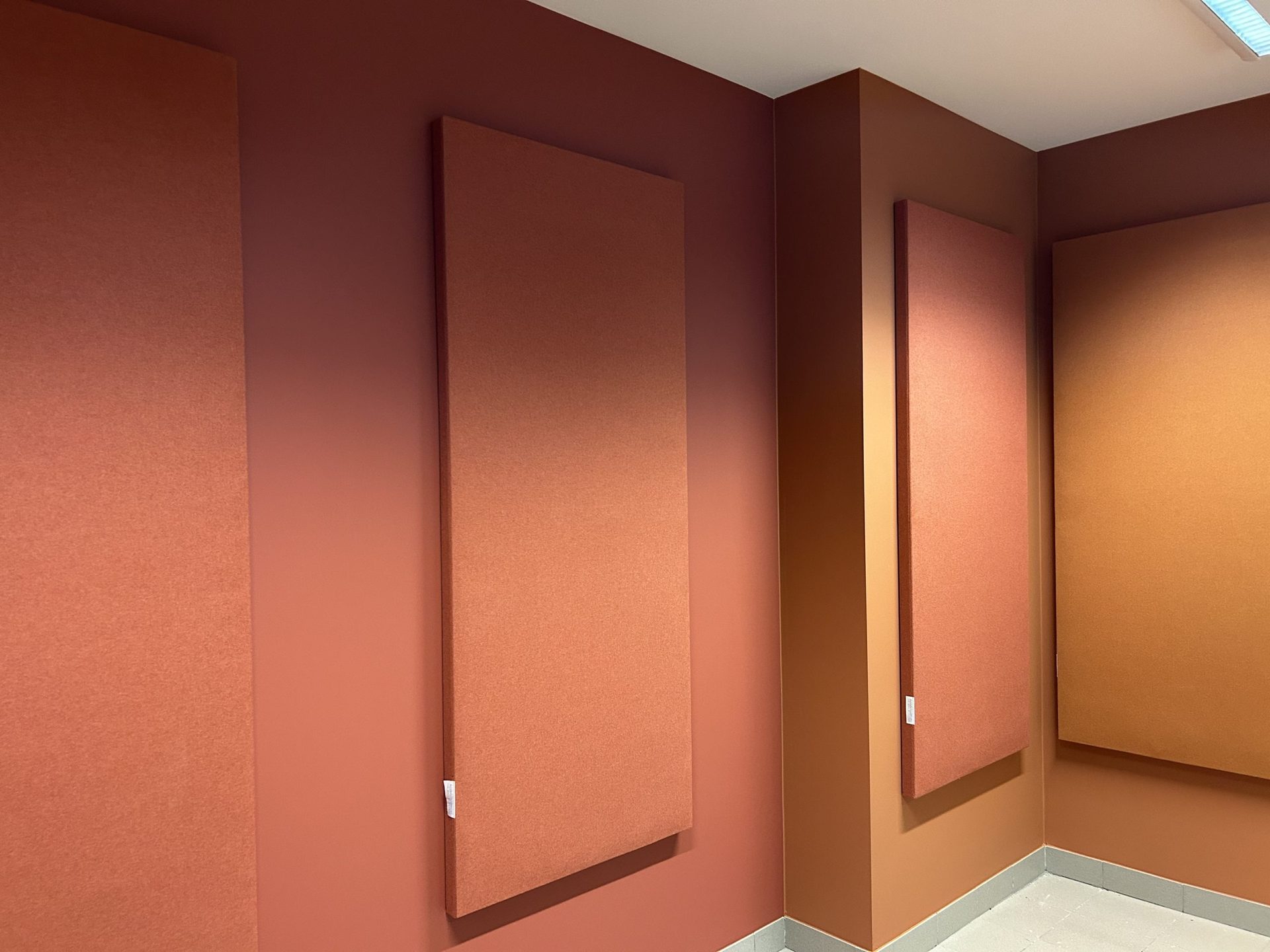 Akoestische wandpanelen in terracotta rond een deur